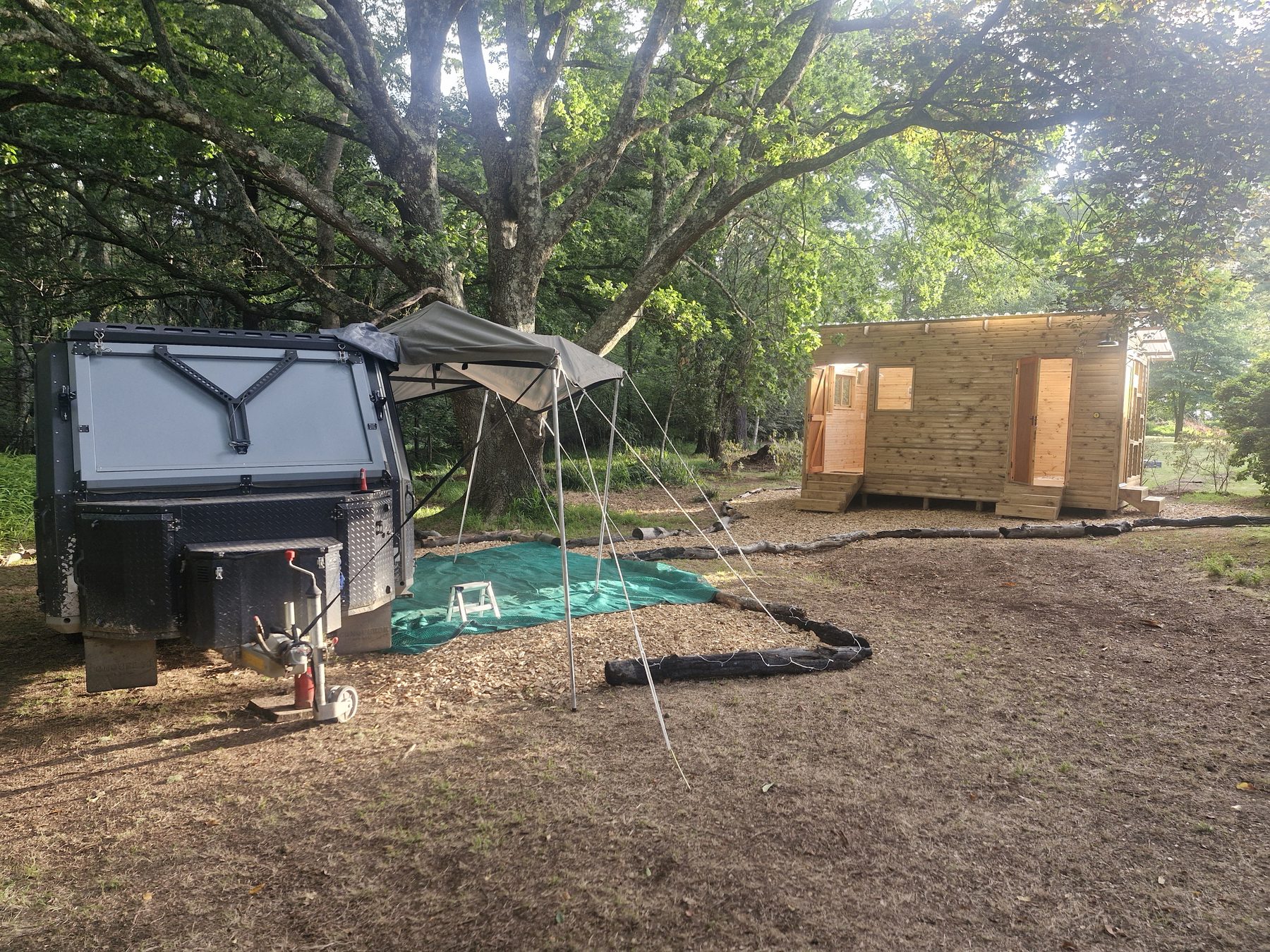 Campsite bays at Maylodge with an off-road caravan, awning and private timber bathroom huts